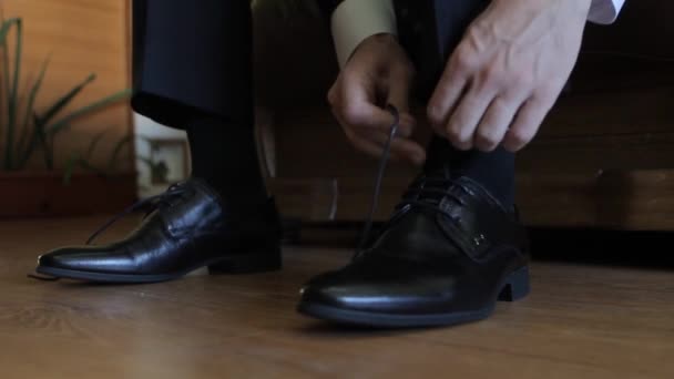 Жених надевает обувь и завязывает шнурки — стоковое видео