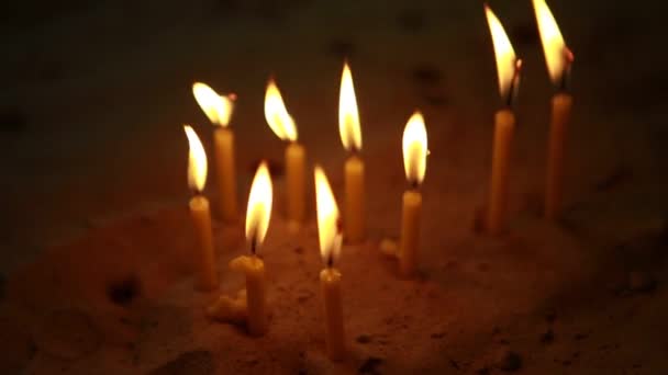 Много свечей в церкви на песке — стоковое видео