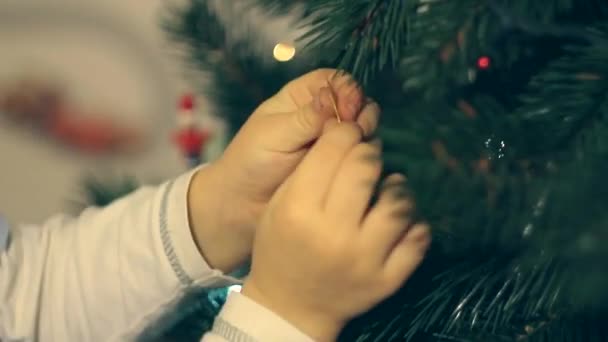 Jongen speelgoed Kerstmis kerstboom versieren — Stockvideo