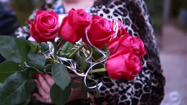 Um buquê de rosas vermelhas nas mãos das mulheres — Vídeo de Stock