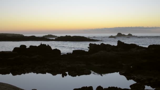 View on ocean and beautiful silhouette of rocks at sunset — Stock Video