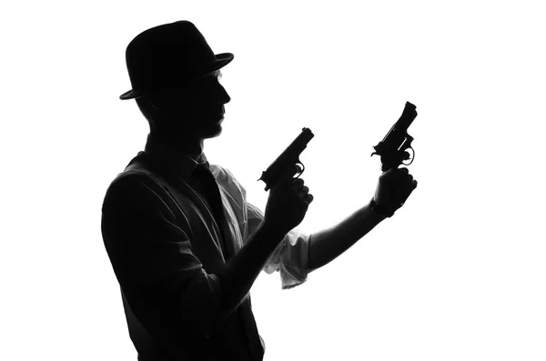 Silhouette of detective with two guns Stock Photo