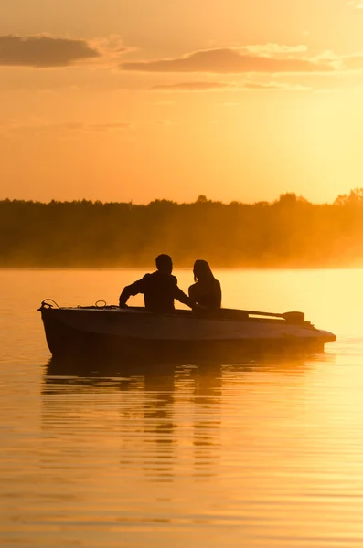 Romantic golden river sunset. Couple on boat backlit by sunlight — Stock Photo, Image