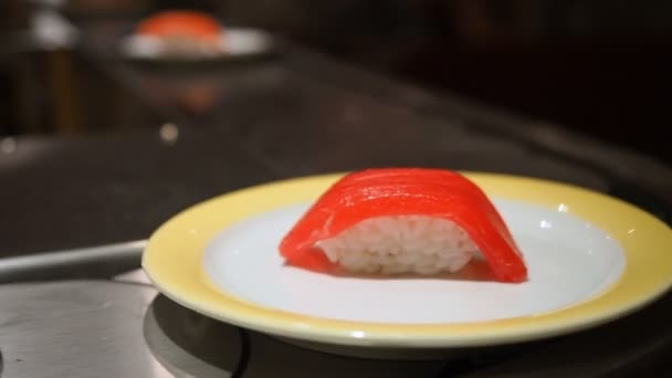 Sushi su piatti che si muovono intorno a un bar di sushi — Video Stock