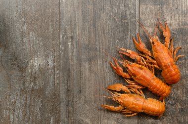 Sol alt köşedeki eski ahşap masa üzerinde üç kırmızı crayfishes