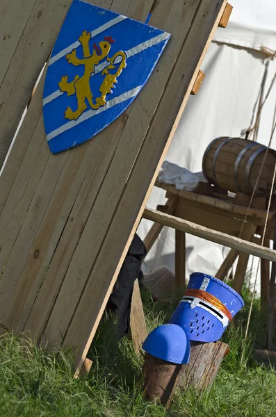 Escudo medieval y casco cerca con campamento de caballeros — Foto de Stock