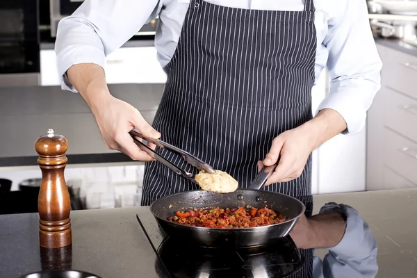 Chef preparing dishes in a frying pan — Stock Photo, Image