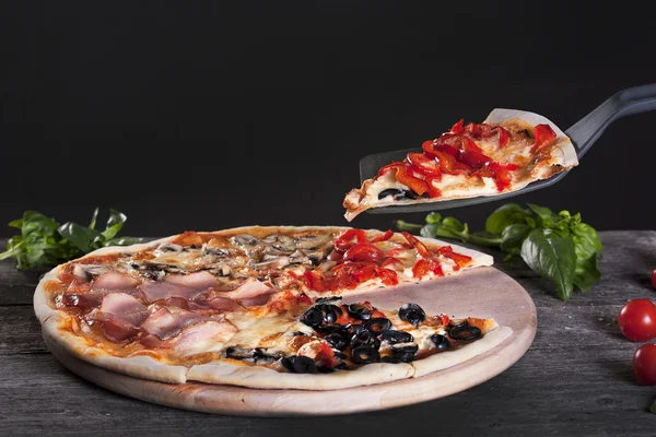 Surtido de pizza con tocino, champiñones, pimientos y aceitunas en el — Foto de Stock