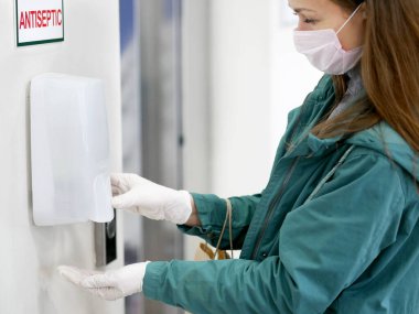 Süpermarkette otomatik dezenfektan kullanan eller. Coronavirüs salgını sırasında bir alışveriş merkezinde dezenfektan..