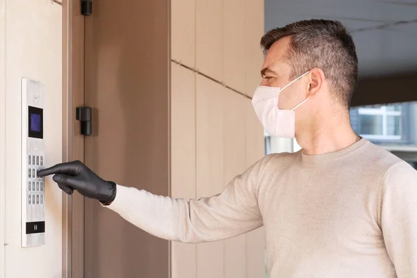 Male in medical mask masked dials the door code — Stock Photo, Image