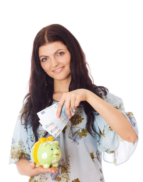 Woman putting euro in piggy bank. — Stock Photo, Image