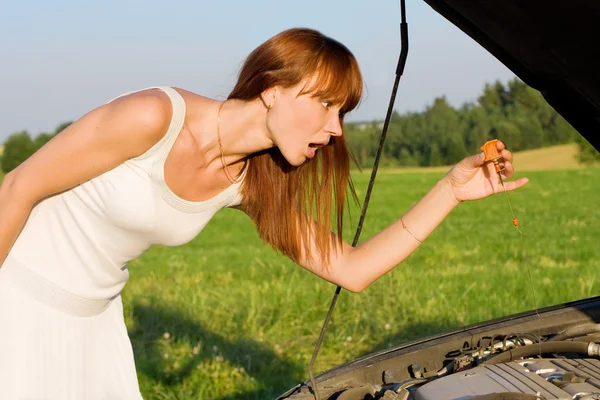 Jonge vrouw gebogen over auto motor — Stockfoto