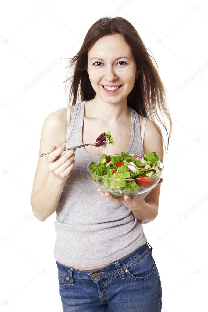 Happy young woman eating salad.