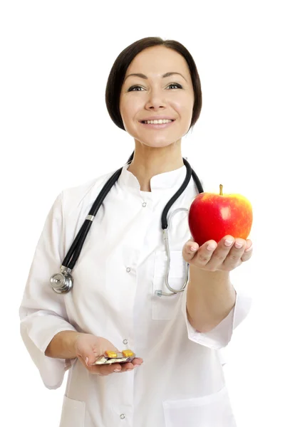 Lekarz trzyma jabłko i tabletki - pień obrazu — Zdjęcie stockowe