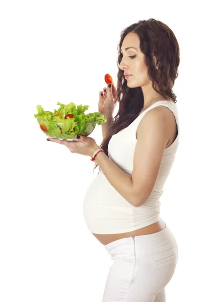 Беременная женщина ест салат. — стоковое фото