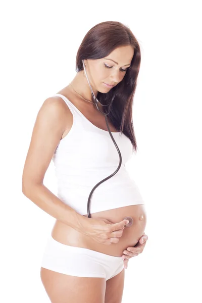 Беременная женщина слушает своего ребенка . — стоковое фото