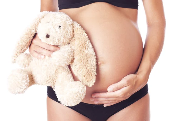Беременная женщина держит мягкую игрушку . — стоковое фото