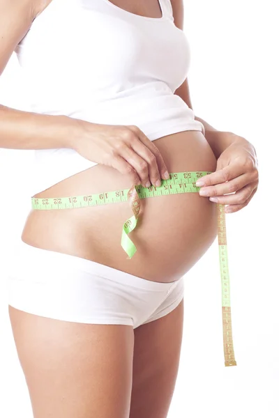 Těhotná žena měřící pás. — Stock fotografie