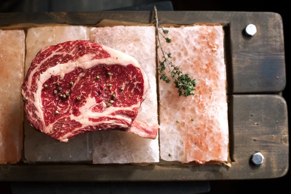 Řádek kosti v Rib Eye Steak na kousky soli — Stock fotografie