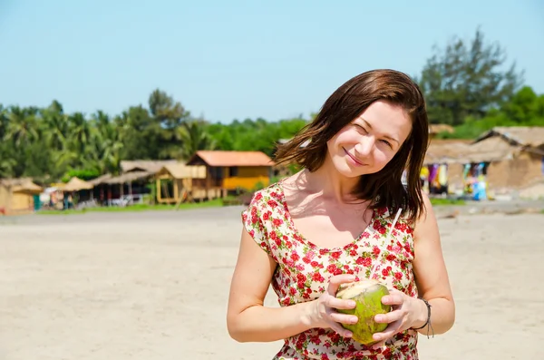 Jovem mulher bebendo leite de coco na praia . — Fotografia de Stock