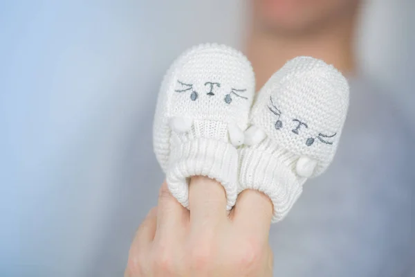 Par de sapatos de lã recém-nascido branco colado no dedo — Fotografia de Stock