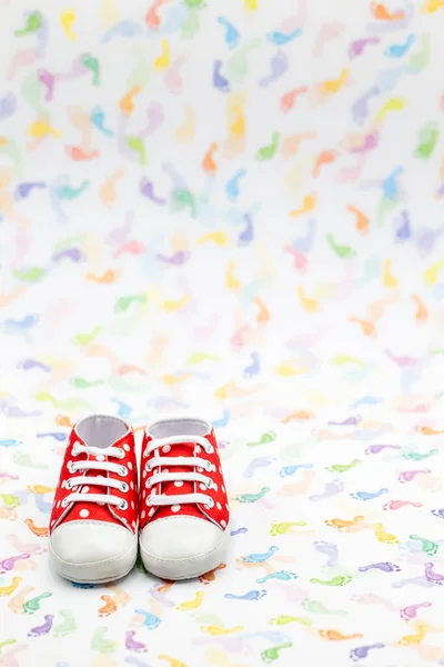 Pár novorozených bot v červené s bílými tečkami na barevném pozadí plus kopírovací prostor — Stock fotografie