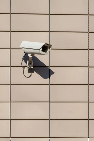 surveillance camera on house facade symbolizes security and control. vertical