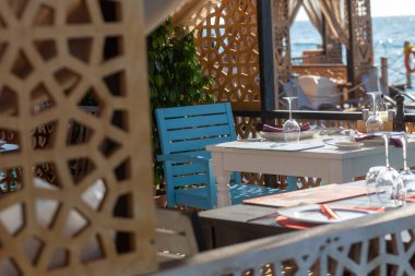 Denize bakan bir restoran ve masaları ters dönmüş hindi bardaklarıyla kaplamış.