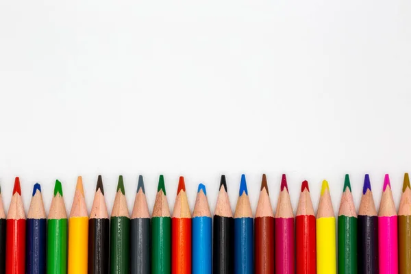 Different colored pencils lined up in different colors with white background for school and arts with copy space for free text. Horizontal
