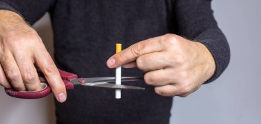 Sigara içmeyi bırakan kişi sigarasını siyah kazaklı bir makasla yok eder ve sigaraya odaklanır. Yatay