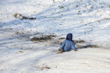 Çocuk tepeden yuvarlanıyordu ve kazara yere düştü..