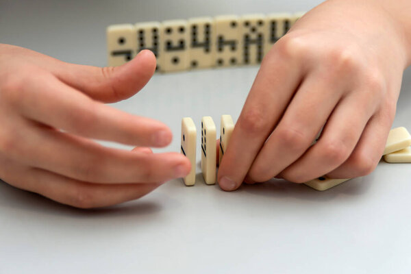 The girl rebuilds the domino wall she broke.