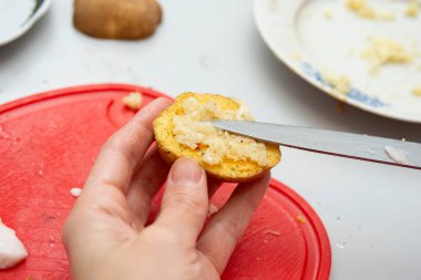 Kız usulca patatese sarımsak sürüyor..