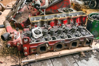 Bir traktörden büyük kırmızı parçalanmış motor.