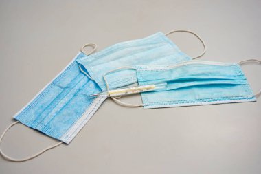 Termometre üç maskenin üzerinde ve masanın üzerinde..