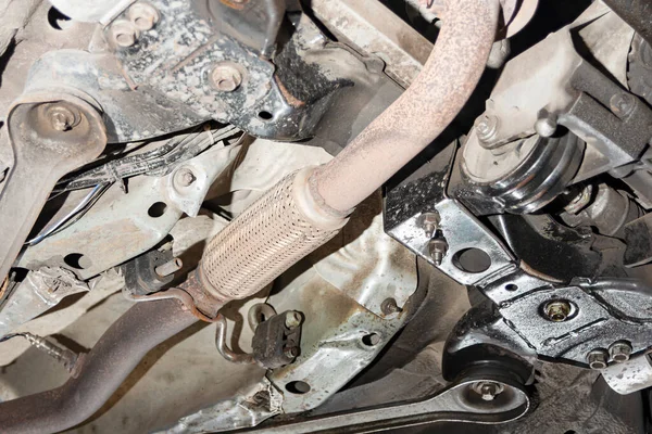 Muffler, resonator of the exhaust system under the car at the service station, bottom view.