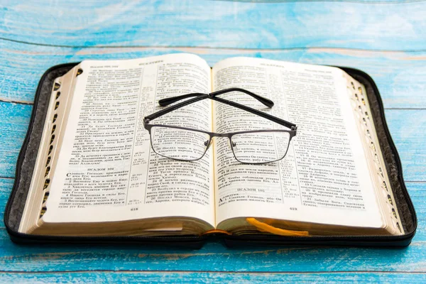 Lunettes Allongées Sur Bible Ouverte Fond Bleu — Photo