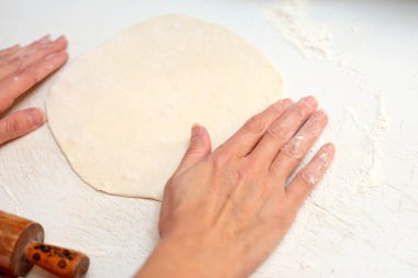 Kız nazikçe çeburek için hamuru düzeltiyor..