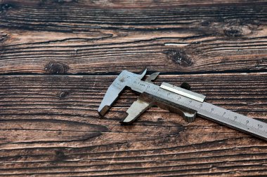 Bir kalibre ahşap bir arka plan masasında yatıyor.