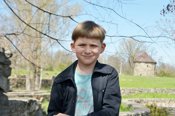 Doğada gülümseyen bir çocuk kameraya bakar..