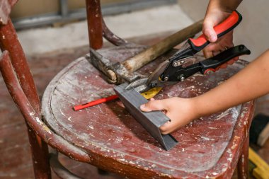 Metal makas kullanarak genç, sandalyede küçük bir alçıpan profili oluşturdu..