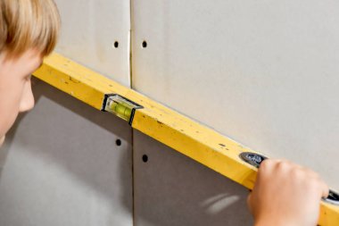 Tecrübesiz bir çocuk alçıpan üzerine bina boyunca bir çizgi çekiyor..