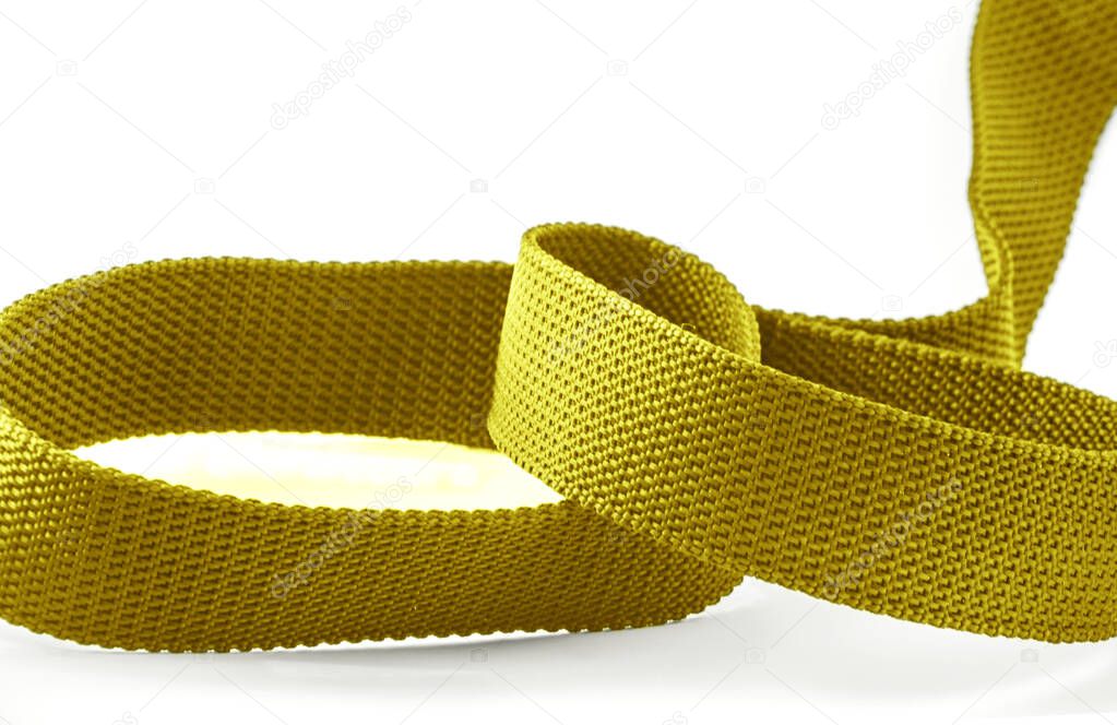 a piece of golden rough textured nylon cloth belt isolated on a white background