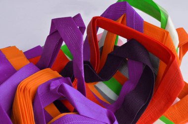 multicolored non-woven fabric tote bag. a collection made from various colors of non-woven fabric.  polypropylene straps are textured and porous.