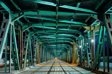 Gece vakti aydınlatılmış yeşil metal köprü