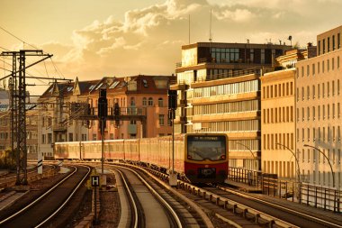 Bahn treni gün batımında Berlin 'de demiryolunda hareket ediyor.