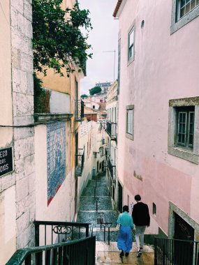 Portekiz, Lizbon 'da yağmurlu bir günde sevgilisiyle el ele yürüyen bir kızın portresi..