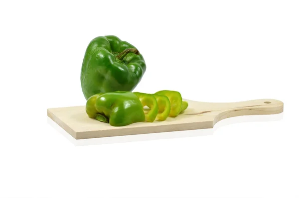 Green pepper sliced on wooden chopping board — Stock Photo, Image