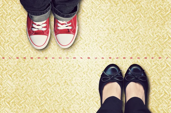 Röda linjen som avgränsar sneakers och klassiska skor — Stockfoto
