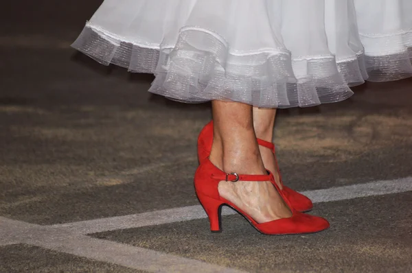 Літня жінка танцює з червоним взуттям і білою сукнею — стокове фото